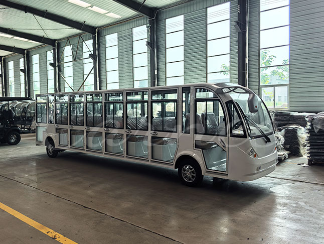 Full side profile of 23-seater enclosed electric shuttle bus inside workshop
