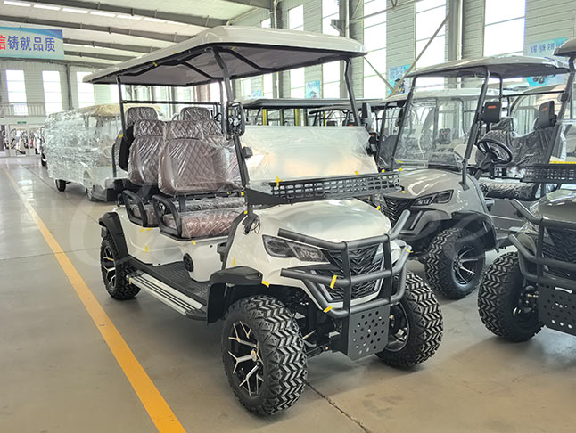 Side angle of white lifted 6 passenger electric golf cart with off-road tires