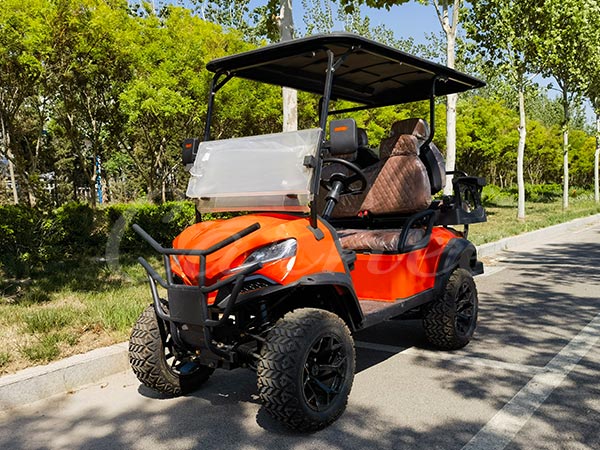 Orange off-road electric golf cart with rugged tires for all-terrain use.
