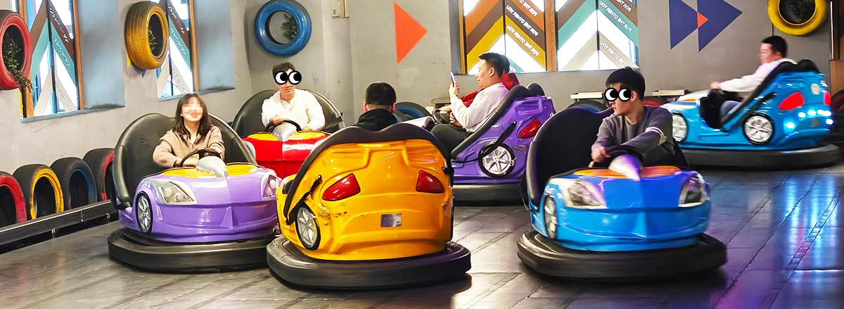 A group of people enjoying bumper cars at an amusement park, with colorful cars and a fun, lively atmosphere.