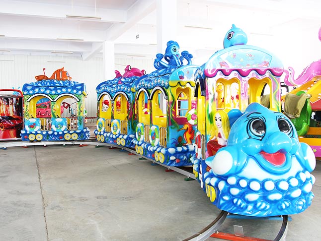 Amusement park ocean train ride with fish design, bright colors, and kid-friendly seating