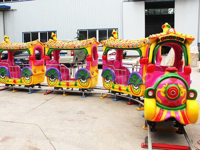 Colorful cartoon-themed kids track train ready for use in the amusement park, featuring fun designs and vibrant colors