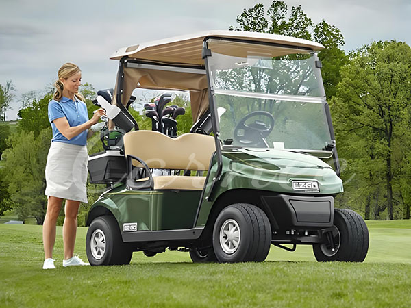 Electric golf cart parked on a golf course, with a woman preparing for a round of golf.