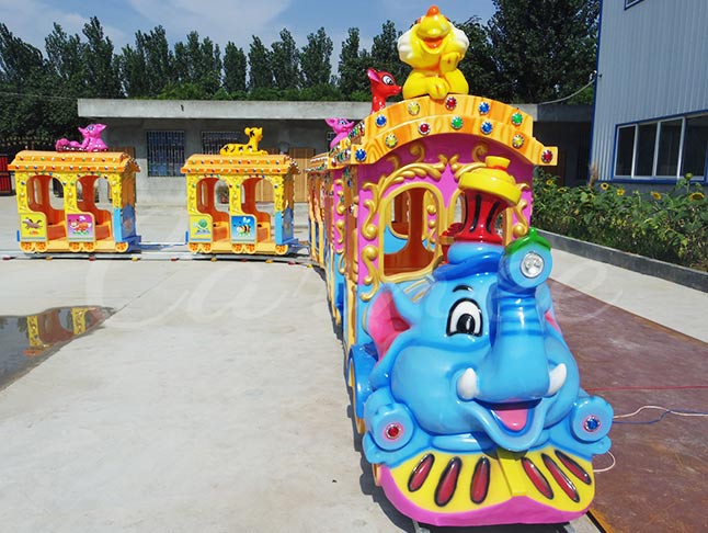 Fun fair elephant track train ride with vibrant colors and adorable animal characters on top.