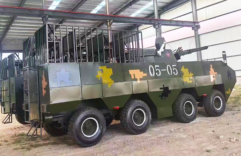 Side view of military-themed amusement armored vehicle produced by Carnee Rides, displayed at the factory.